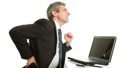 Business man in suit has back pain from standing at his desk